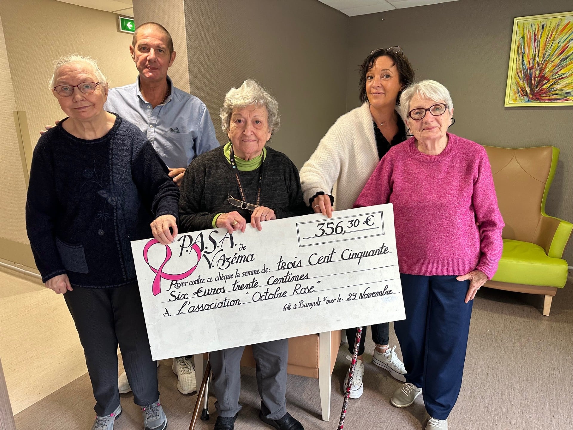Personnes âgées remettant un chèque de 356€ à l'association Octobre Rose